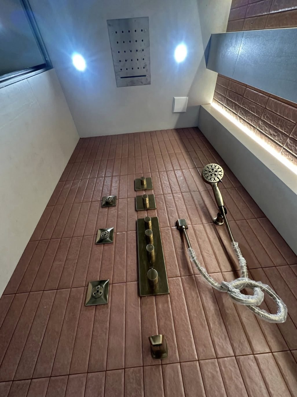 Brushed gold concealed shower system with body jets and a ceiling mounted shower head